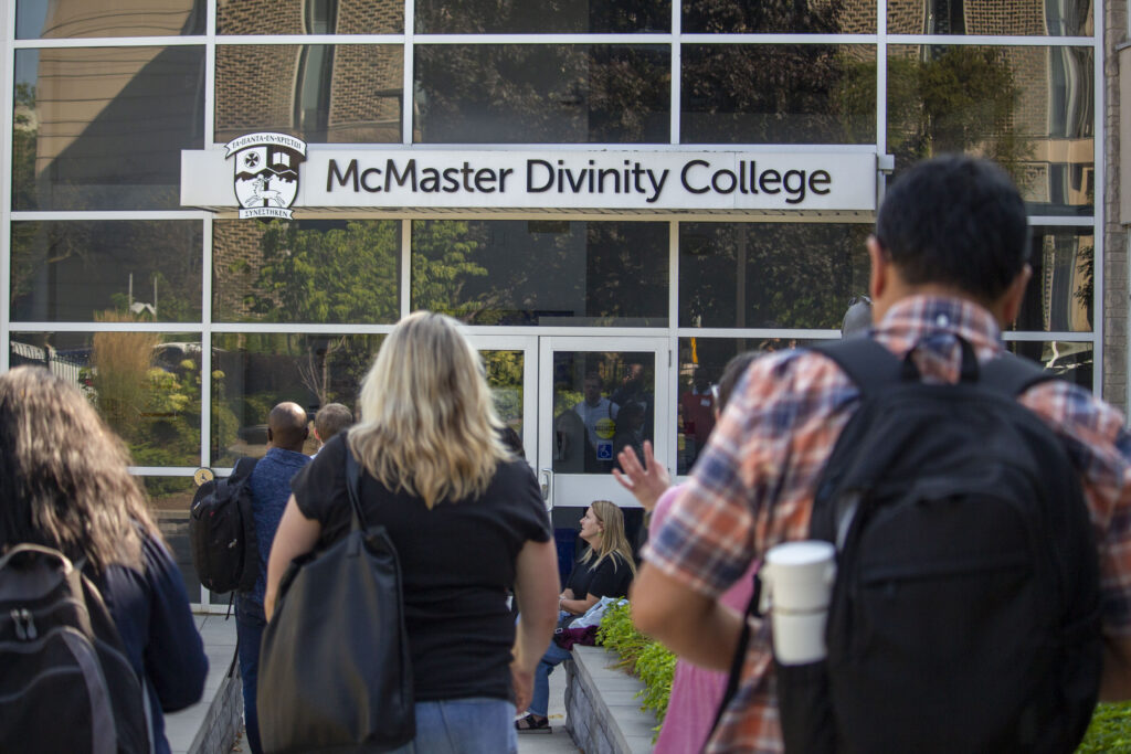 Students walking into the McMaster Divinity College building
